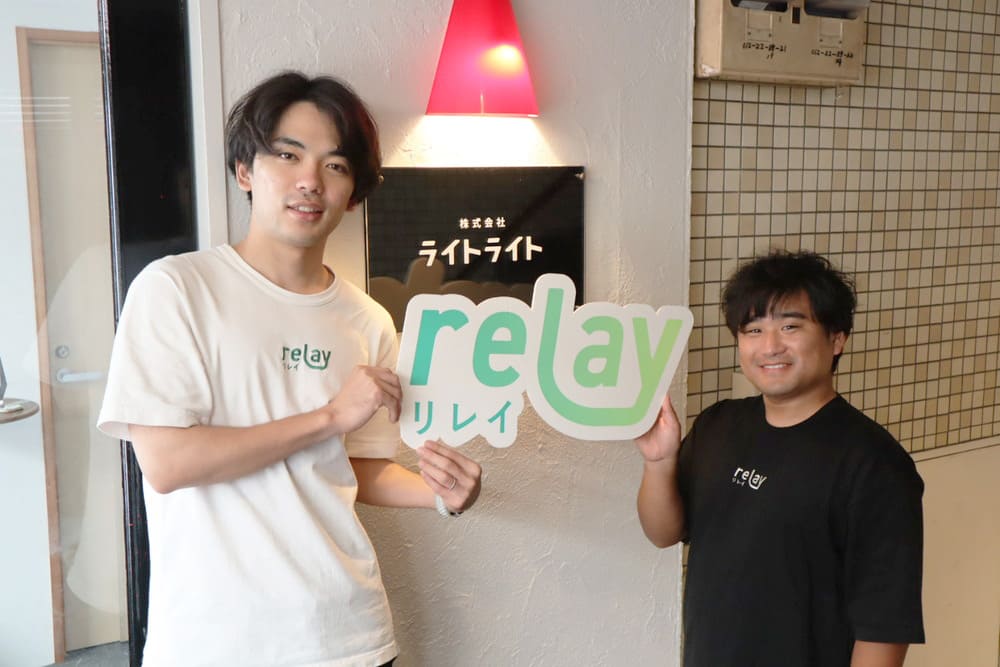 relayのロゴを持つ満園さんと松田さん